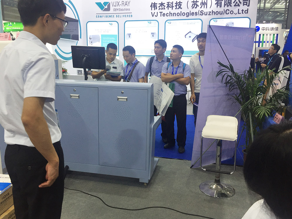 我司參展工作人員（yuán）為觀展者介紹安檢機安檢門